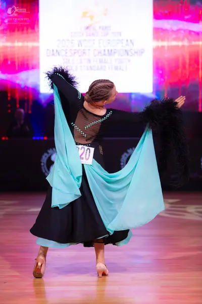 Dancesport competitor: Female dancer: black ballroom dress with a tan mesh back panel decorated with si