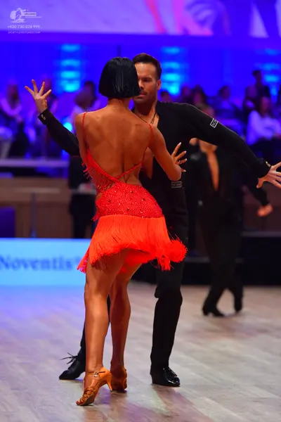 Dancesport competitor: Female dancer: red backless latin dress with fringe