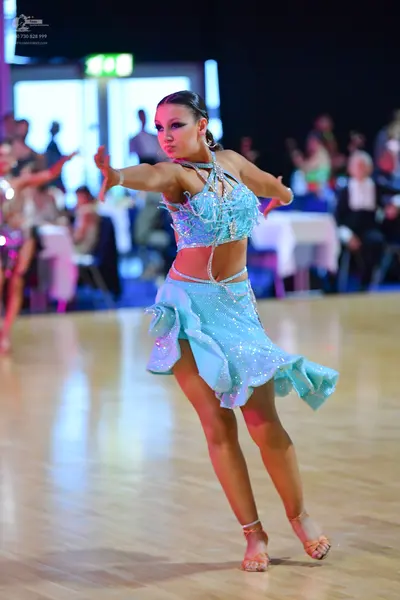 Dancesport competitor: Female dancer: light blue Latin dance costume with silver sequins, featuring a c