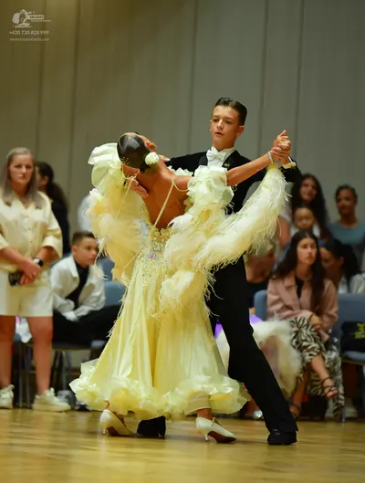 Dancesport competitor: Male dancer: black suit with a white shirt and a white bow tie