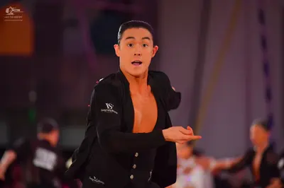 Dancesport competitor: Male dancer: black long-sleeved dance top, open at the chest