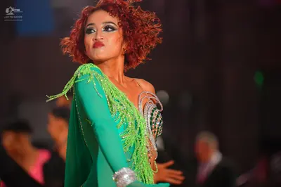 Dancesport competitor: Female dancer: green Latin dress with long sleeves, lime green fringe/beadwork, 