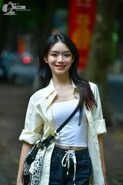 Dancesport competitor: Female dancer: white tube top, light yellow unbuttoned long-sleeve shirt, black 