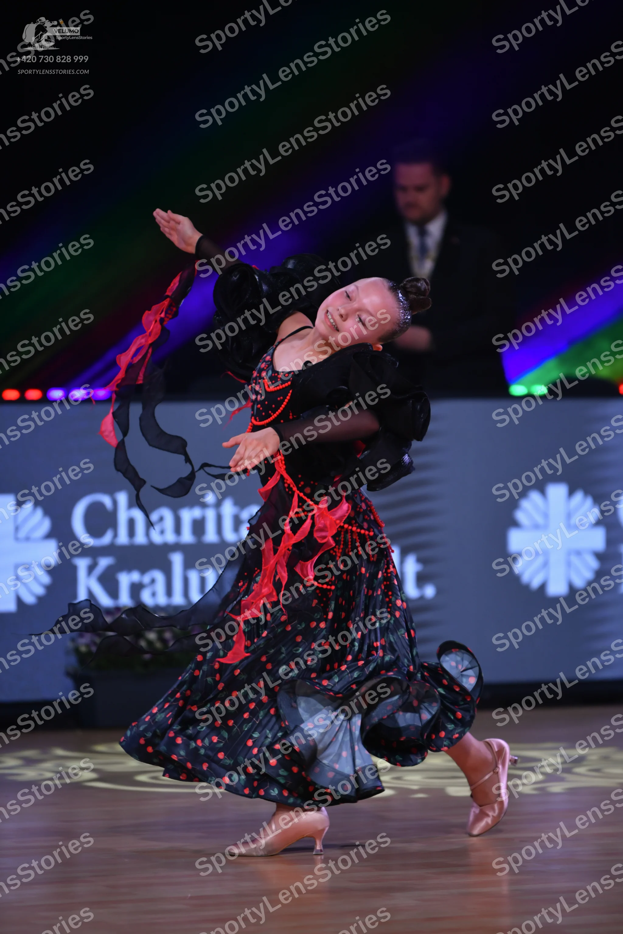 Dancesport competitor: Female dancer: black ballgown with red flame patterns, long sleeves, and a volum