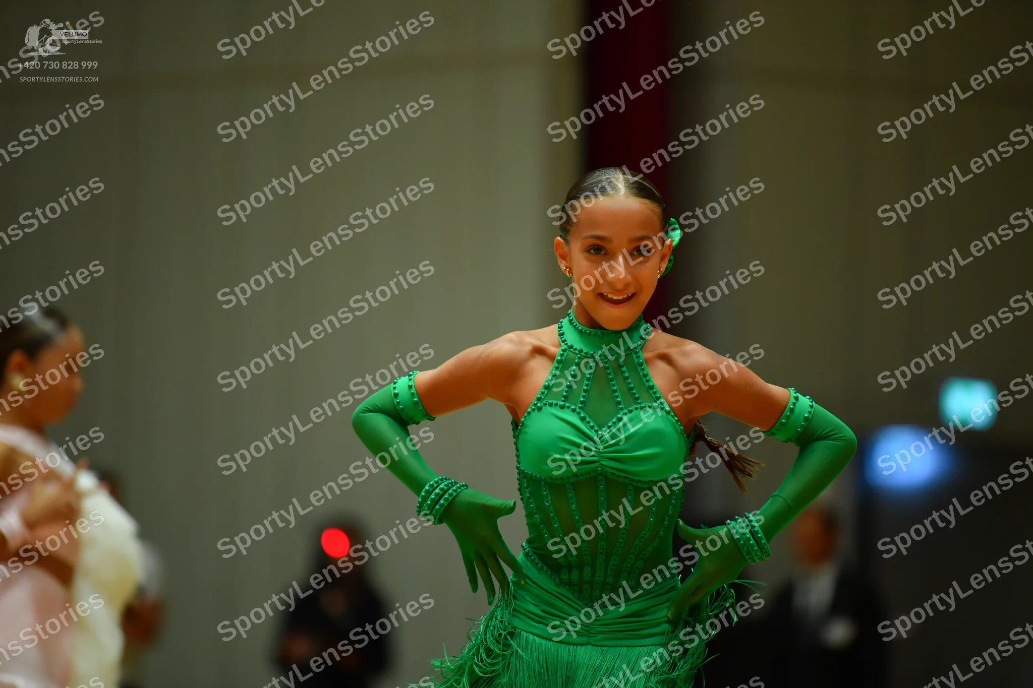 Dancesport competitor: Female dancer in center: bright green Latin dance dress with sequins, a halter n