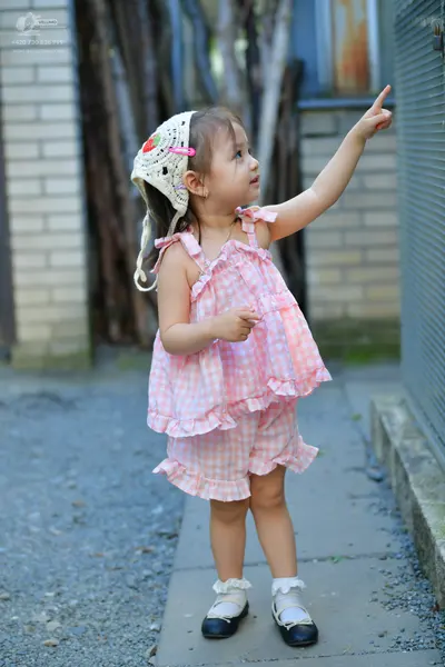 Dancesport competitor: Female dancer: pink and white gingham patterned sleeveless ruffled top and match