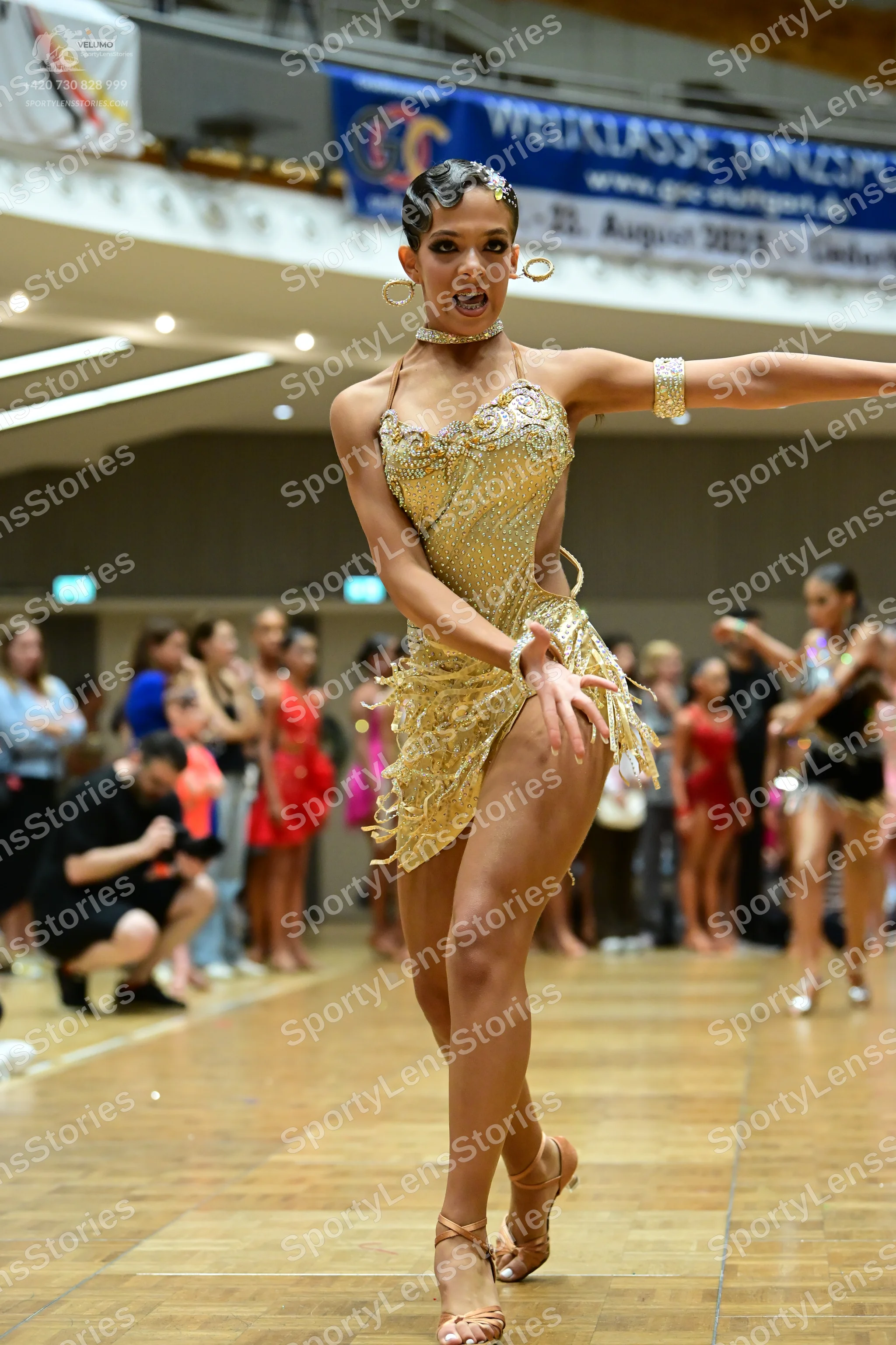 Dancesport competitor: Main dancer: gold sequined latin dress with fringe, crystals, halter neck, gold