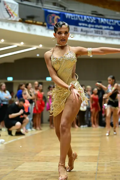 Dancesport competitor: Main dancer: gold sequined latin dress with fringe, crystals, halter neck, gold 