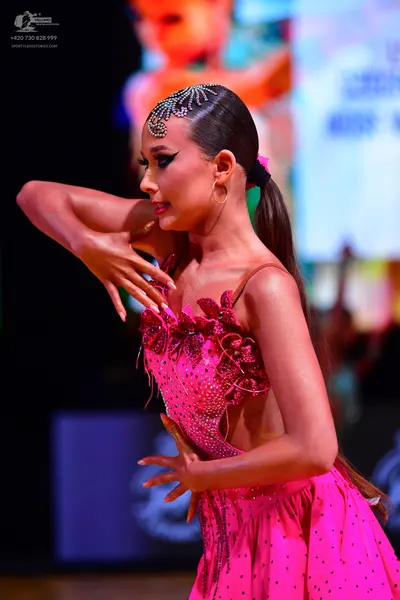 Dancesport competitor: Female dancer: bright pink latin dress with sequins and floral-like embellishmen