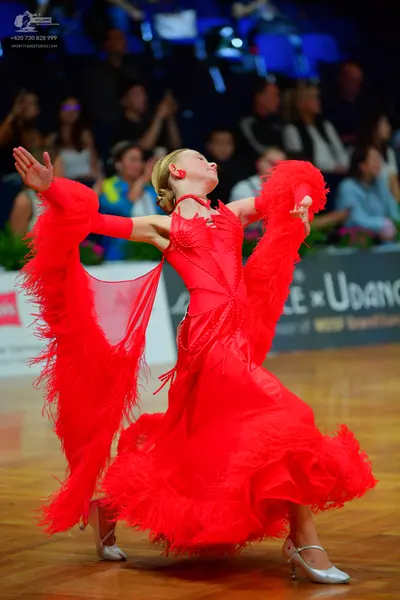Dancesport competitor: Female dancer: red latin dress with voluminous ruffles and fringe