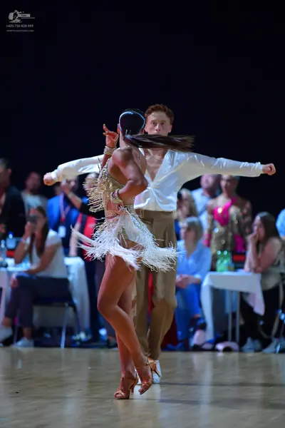 Dancesport competitor: Male dancer: white long-sleeved shirt and tan trousers