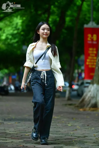 Dancesport competitor: Female dancer: white crop top, cream-colored open button-down shirt, black baggy