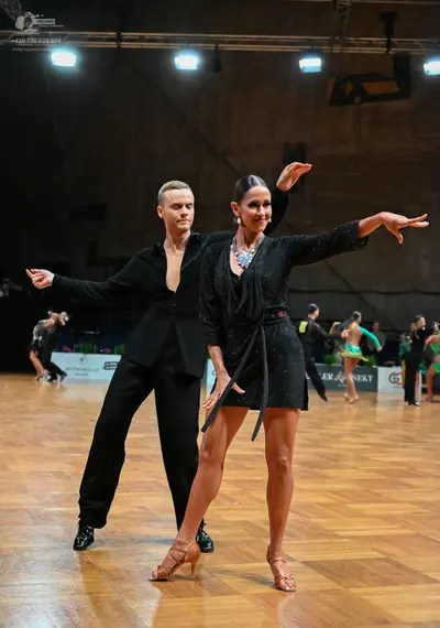 Dancesport competitor: Male dancer: black suit with a deep V-neckline and black trousers