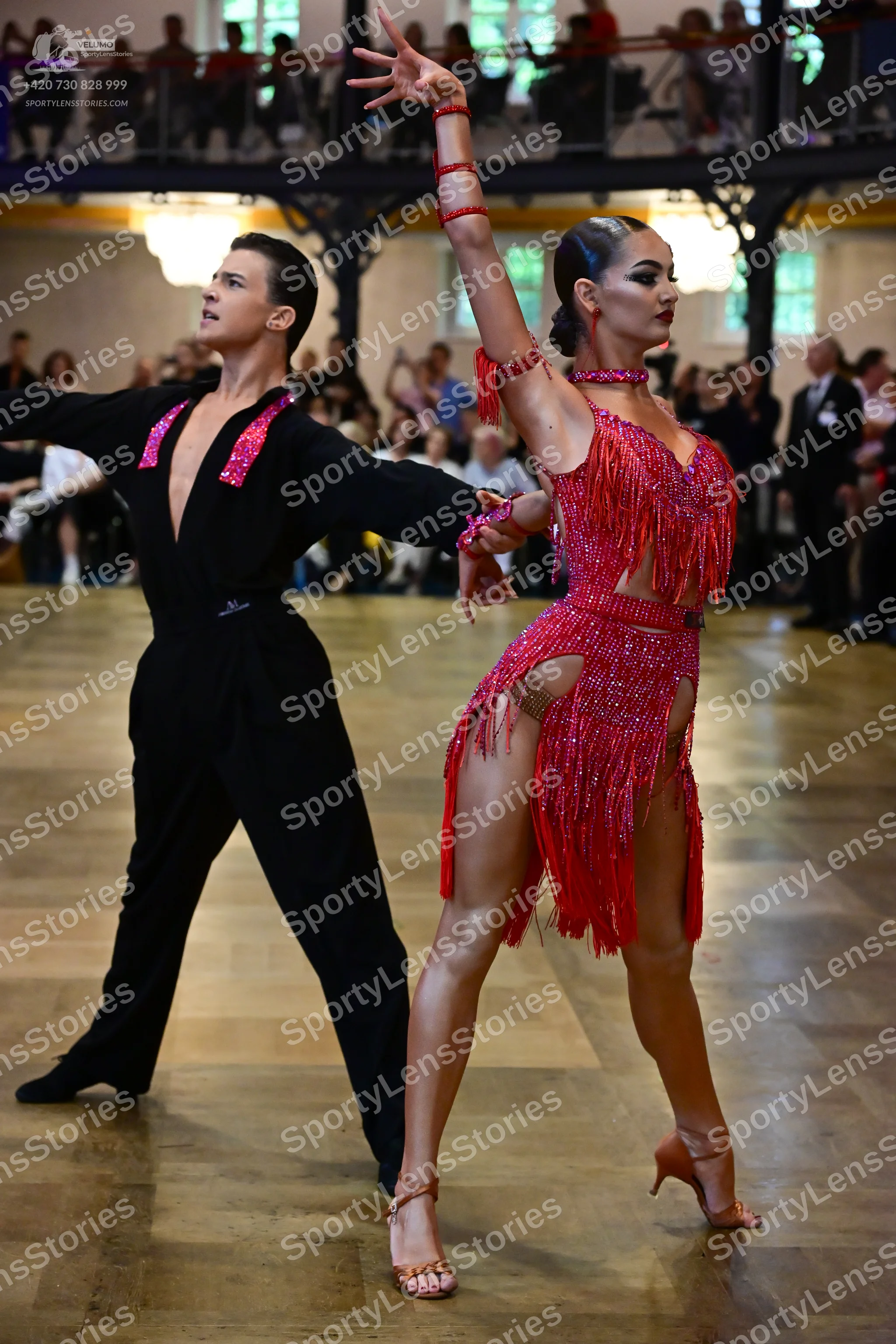 Dancesport competitor: Male dancer: black long-sleeved shirt with red sequined embellishments on the ch