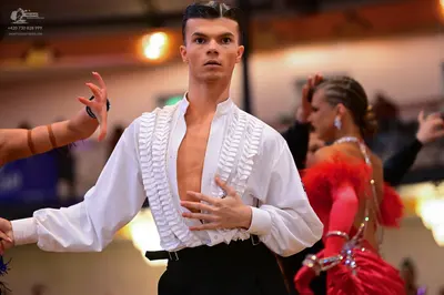 Dancesport competitor: Male dancer: white long-sleeved shirt with ruffles on the front and black trouse