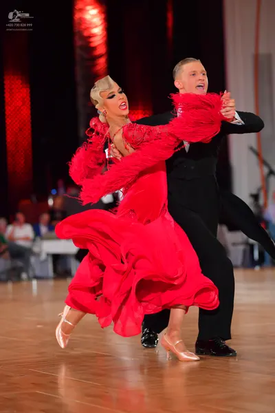 Dancesport competitor: Female dancer: red latin dress with voluminous flowing skirt and textured/fringe