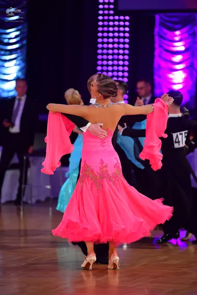 Dancesport competitor #475: Female dancer: bright pink ballroom dress with a lace-detailed bodice, a volumin