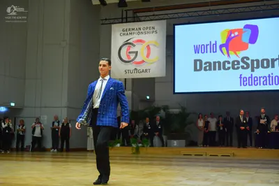 Dancesport competitor: Male dancer: bright blue patterned blazer, white shirt, blue and white patterned