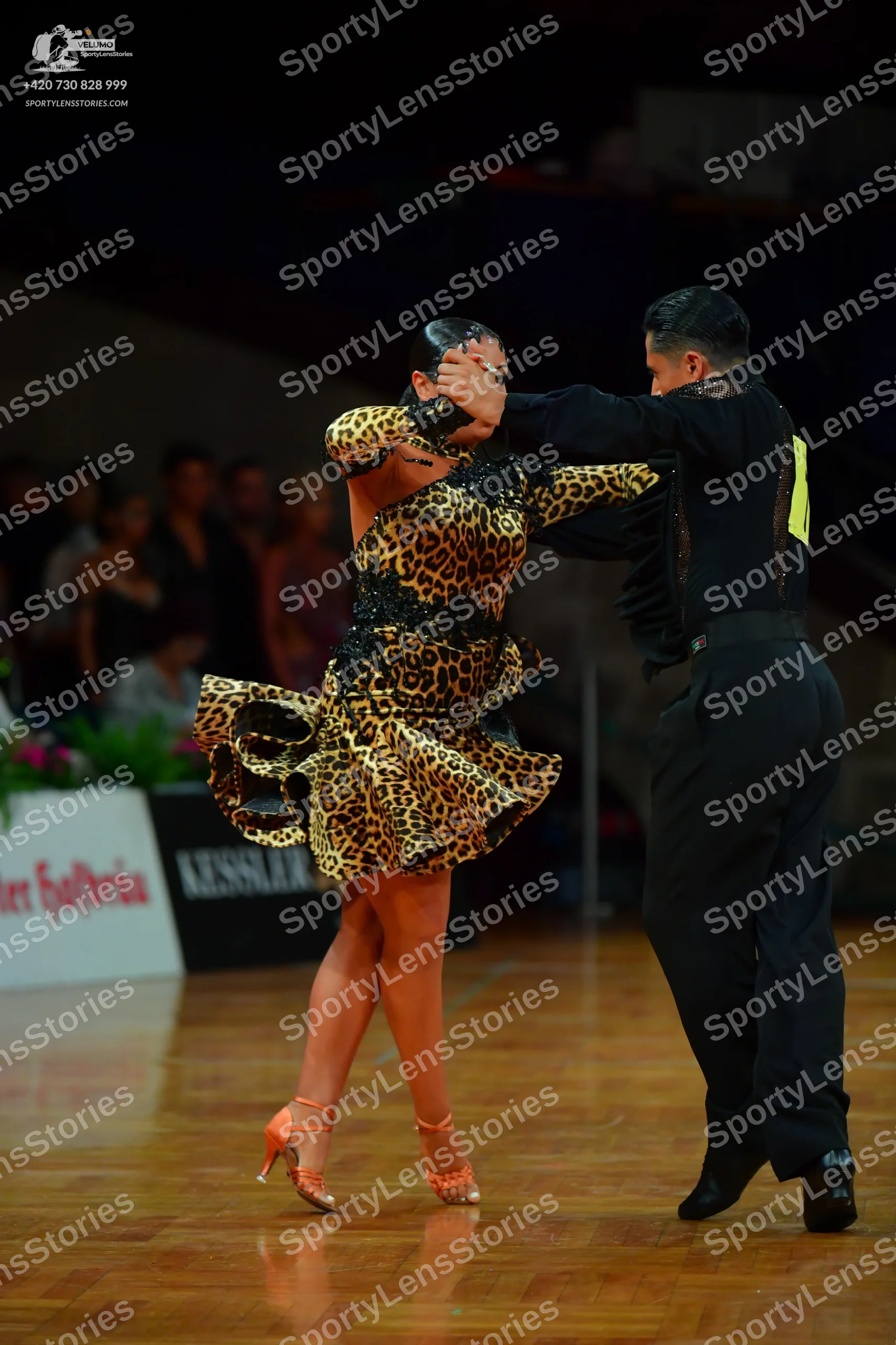 Dancesport competitor: Male dancer: black long-sleeved shirt with yellow/gold detail on the shoulder an