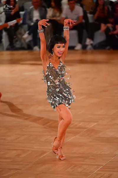 Dancesport competitor: Female dancer: silver latin dress covered in large metallic sequins