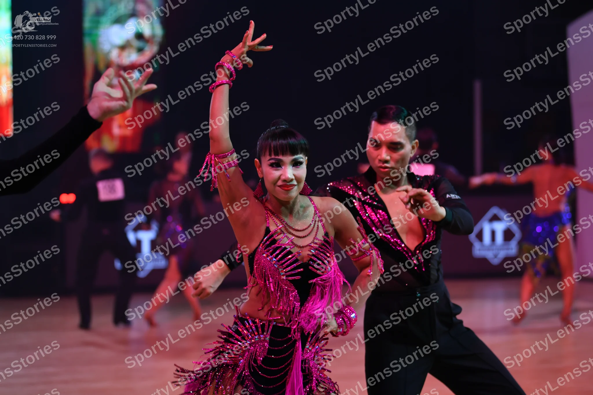 Dancesport competitor: Male dancer: black dance shirt with pink/magenta sequin embellishments on the ch