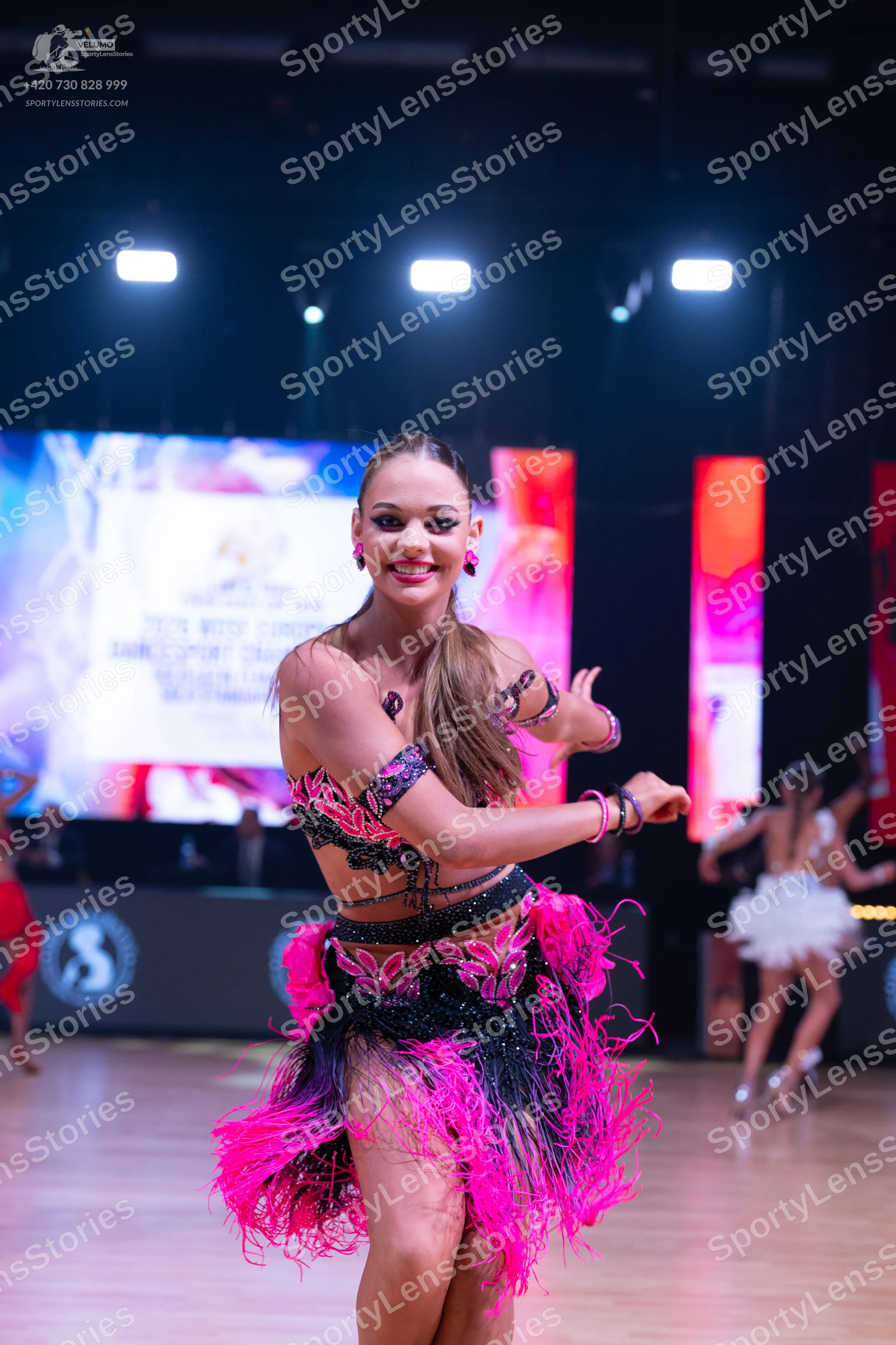 Dancesport competitor: Main dancer: black and bright pink Latin dance dress with sequin embellishments