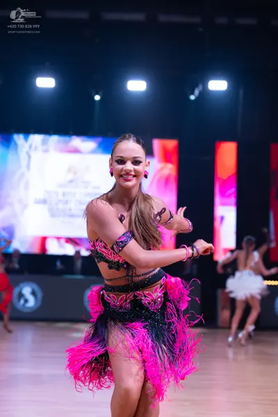Dancesport competitor: Main dancer: black and bright pink Latin dance dress with sequin embellishments 