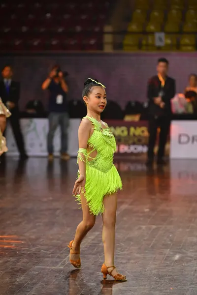 Dancesport competitor: Female dancer: neon green Latin dress with heavy fringe and a sequined bodice, p