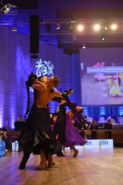 Dancesport competitor: Male dancer (foreground): black trousers and a black top or shirtless