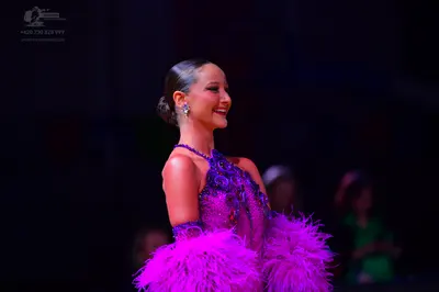 Dancesport competitor: Female dancer: purple latin dress with sequins and large purple feathers