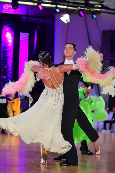 Dancesport competitor: Male dancer: black suit with a white shirt and white bow tie