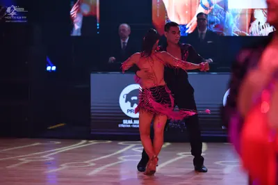 Dancesport competitor: Female dancer: pink latin dress with fringe and shiny fabric