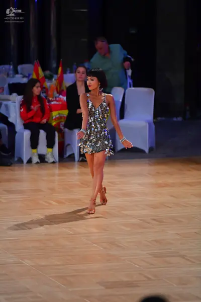 Dancesport competitor: Female dancer: silver sequin latin dress, sleeveless with a V-neckline