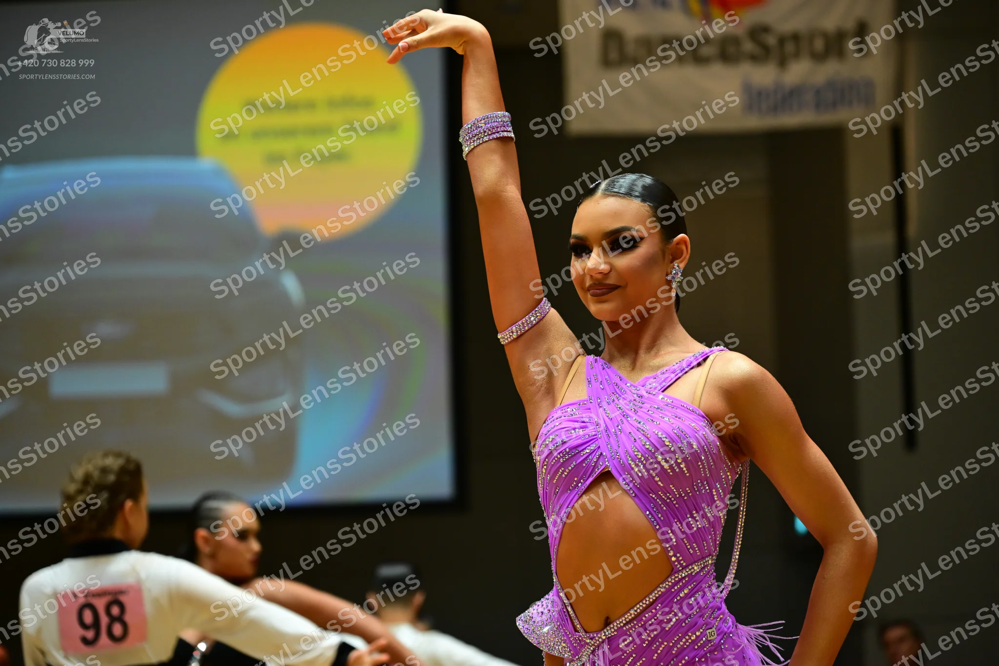 Dancesport competitor #98: Female dancer: purple Latin dress with sequins and cut-out details, matching seq
