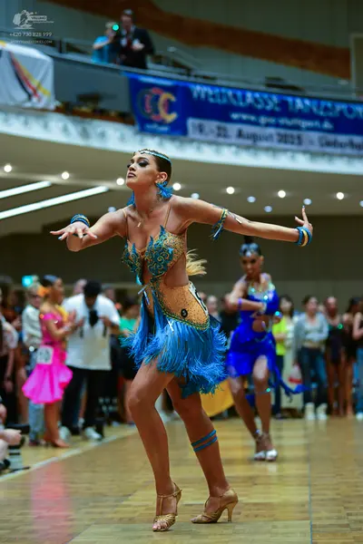 Dancesport competitor #16: Main dancer: tan latin dance dress with blue sequin patterns, blue fringe skirt,