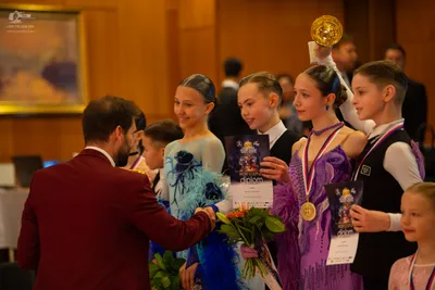 Dancesport competitor: Female dancer: light blue/teal dress with dark blue floral patterns and sheer/me