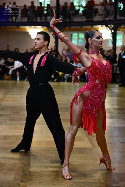 Dancesport competitor: Male dancer: black Latin dance shirt with red sequined trim along the V-neckline