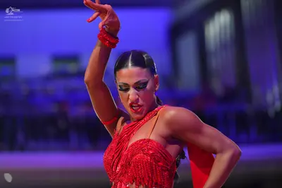 Dancesport competitor: Female dancer: red Latin dress with sequin and bead embellishments, featuring an
