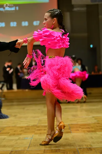 Dancesport competitor #354: Female dancer: bright pink Latin dress with a ruffled top, a voluminous feathery