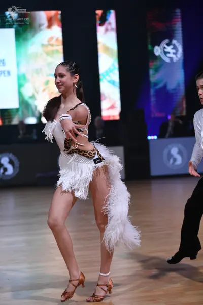 Dancesport competitor: Female dancer: white Latin dance costume with leopard print accents, featuring l