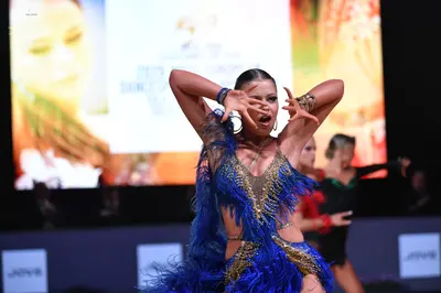 Dancesport competitor: Female dancer: royal blue and gold Latin dance costume with gold sequins, blue f