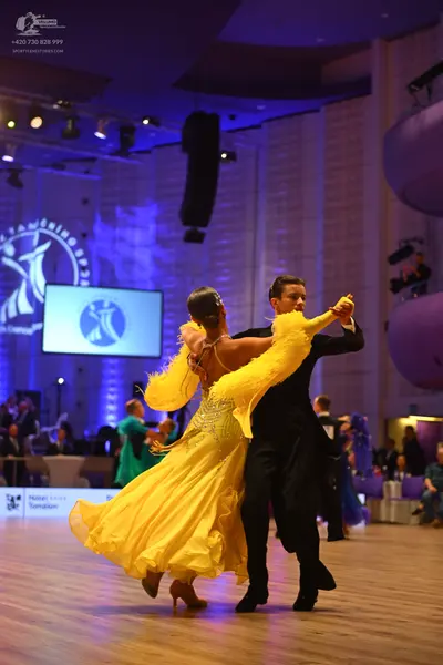 Dancesport competitor: Female dancer: yellow Latin dance dress with an embellished bodice and a flowing
