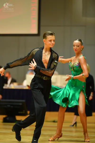 Dancesport competitor: Male dancer: black long-sleeved shirt with mesh sleeves and an open front, black