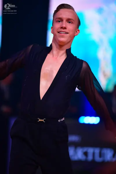 Dancesport competitor: Male dancer: black sheer long-sleeved top with a deep V-neck and subtle sparkle,