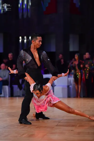 Dancesport competitor: Male dancer: black long-sleeved shirt with silver sequin embellishments and blac