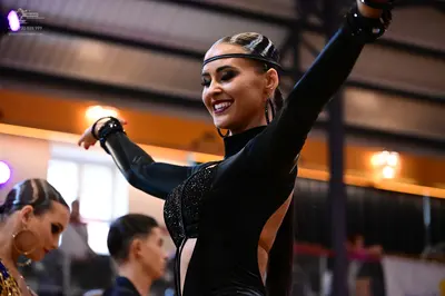 Dancesport competitor: Main female dancer: black long-sleeved latin dance costume with a sequined bodic