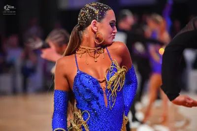 Dancesport competitor: Female dancer: blue sequined latin dress with gold cord detailing and a deep nec