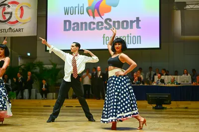 Dancesport competitor: Male dancer: white long-sleeved button-down shirt with a patterned tie and black