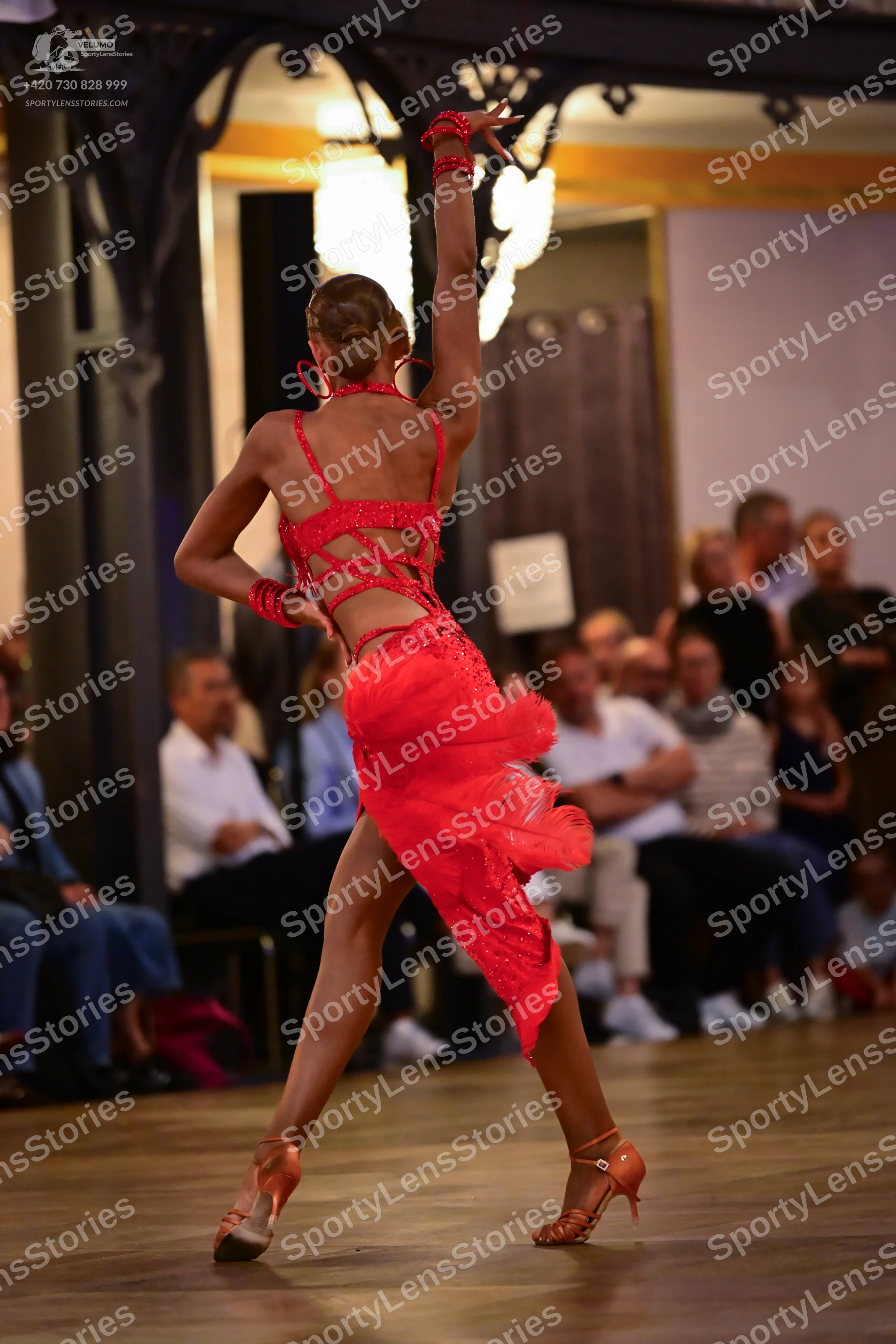 Dancesport competitor: Female dancer: red Latin dress with a high slit, backless design with crisscross