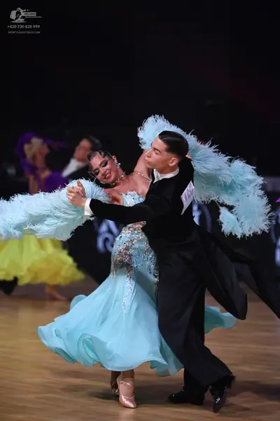Dancesport competitor: Main female dancer: light blue ballroom gown with a flowing skirt, a bodice feat